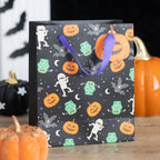 Monster Mash Halloween trick or treat gift bag with pumpkins, bats, mummies and green monsters, styled with spooky pumpkin decorations
