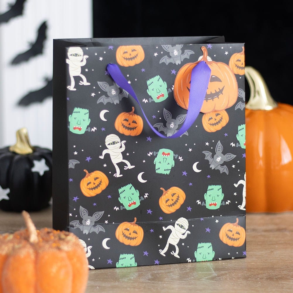 Monster Mash Halloween trick or treat gift bag with pumpkins, bats, mummies and green monsters, styled with spooky pumpkin decorations