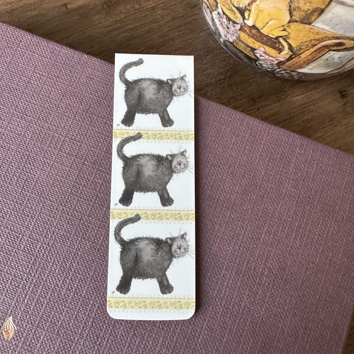 Alex Clark Little Treacle magnetic bookmark displayed on a closed journal, highlighting the compact magnetic design and playful cat artwork.