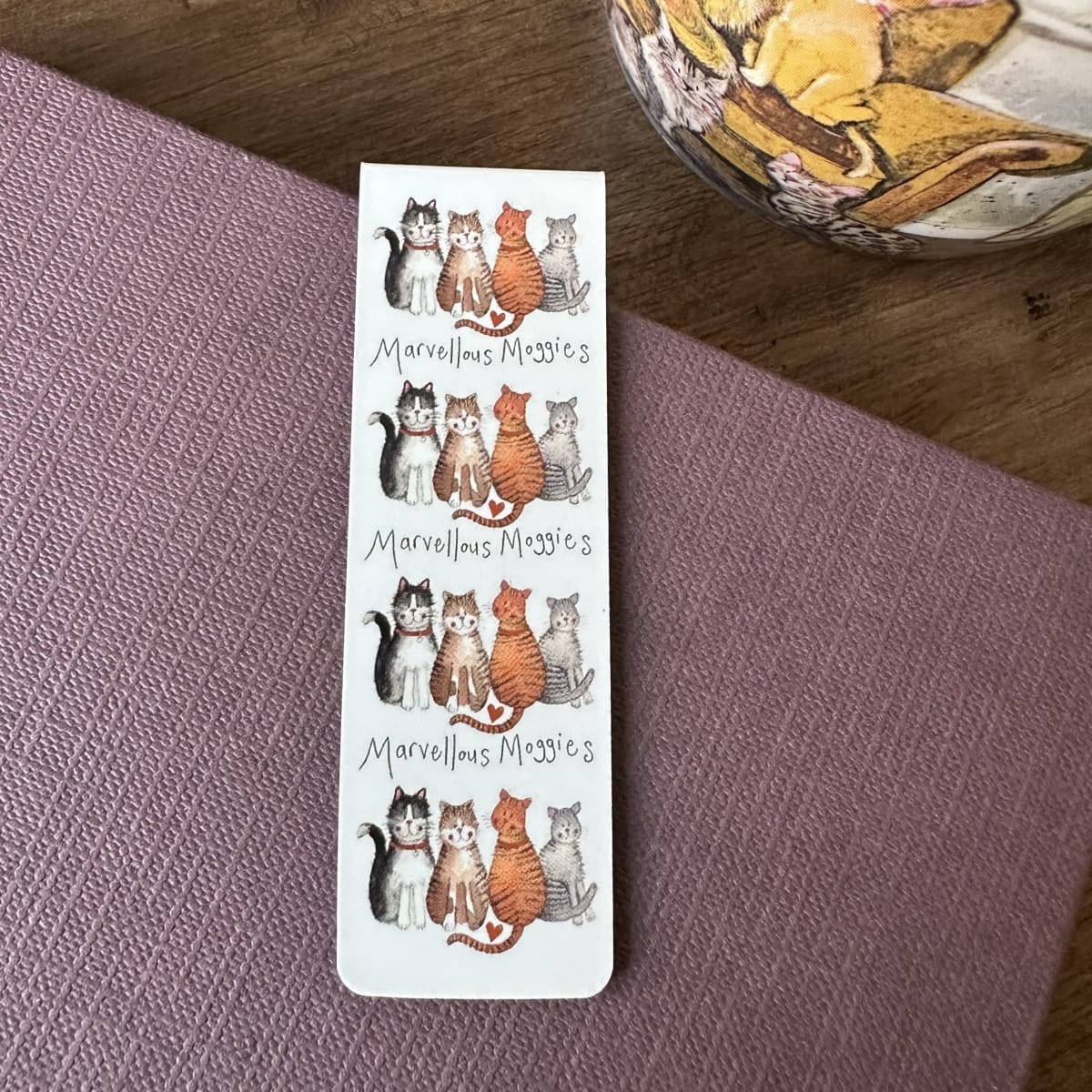 Alex Clark Marvellous Moggies magnetic bookmark displayed on a closed journal, highlighting the compact magnetic design and charming cat artwork.
