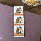 Alex Clark Tortoiseshells magnetic bookmark displayed on a closed journal, highlighting the beautiful watercolour artwork of two companion cats.