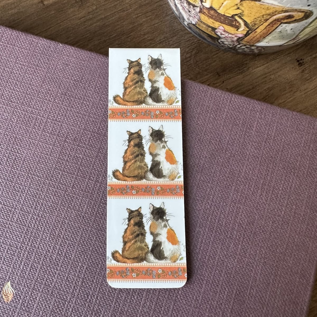 Alex Clark Tortoiseshells magnetic bookmark displayed on a closed journal, highlighting the beautiful watercolour artwork of two companion cats.