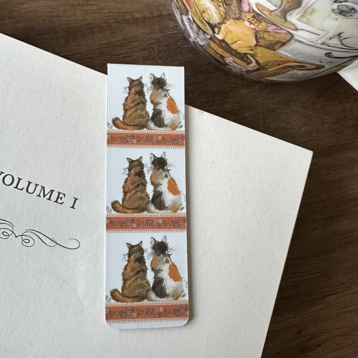 Alex Clark Tortoiseshells magnetic cat bookmark clipped onto the page of an open book, showing how the magnetic bookmark securely holds your place.