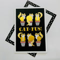 Art File Cat-Tus any occasion cat greetings card featuring six cats disguised as cacti in plant pots with gold-coloured accents and embossed details on a black background.
