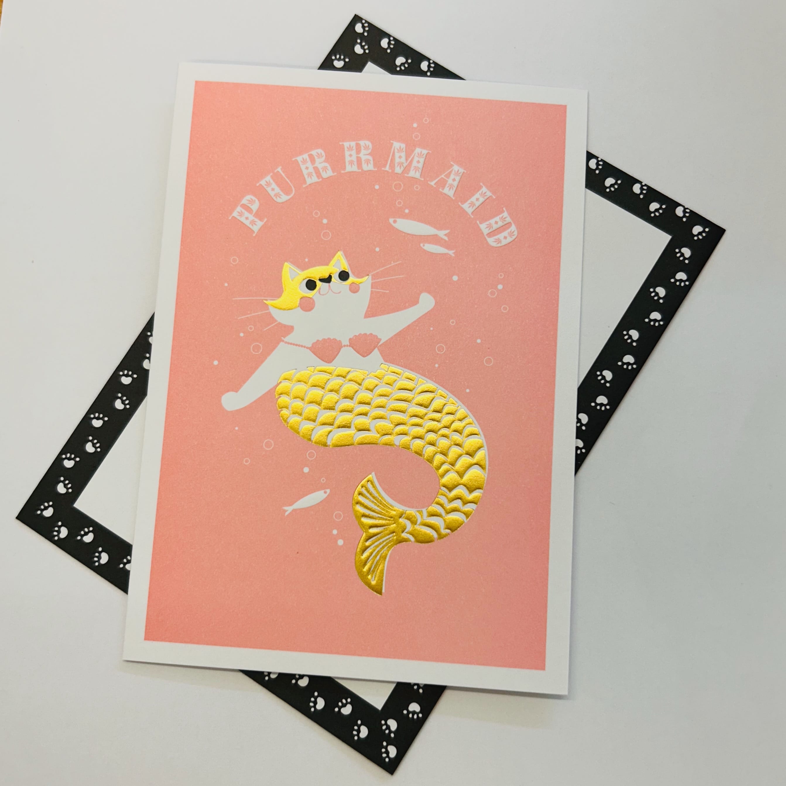 Art File Purrmaid any occasion cat greetings card featuring a cat mermaid with a gold-coloured tail, embossed details and a pink background.