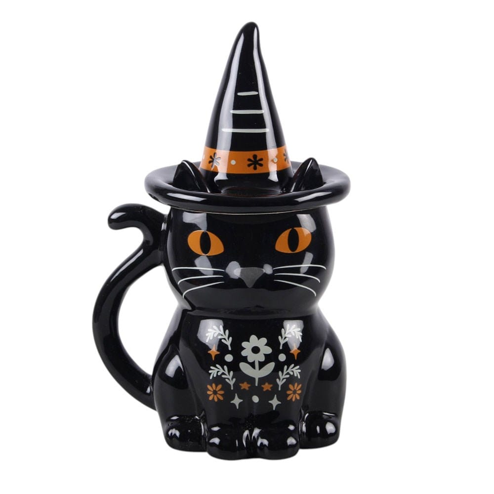 Front view of witchy black cat Halloween lidded mug with orange eyes, floral folk artwork, cat-tail handle and pointed witch's hat