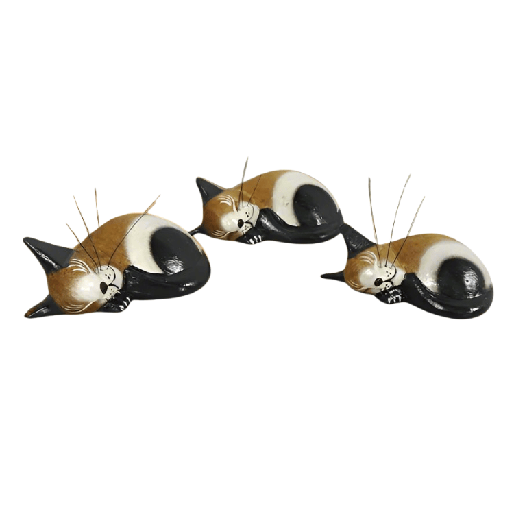 Set of three Fair Trade handmade wooden sleeping cat ornaments in brown, black and cream, with curled-up bodies and delicate whiskers.