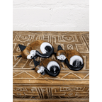 Three hand-carved wooden sleeping cat ornaments displayed together on a rustic carved wooden surface, showing their different sizes.