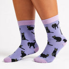 Model wearing Socktopus Black Cats bamboo socks in lilac, showing the colourful black cat pattern and comfortable mid-calf fit.