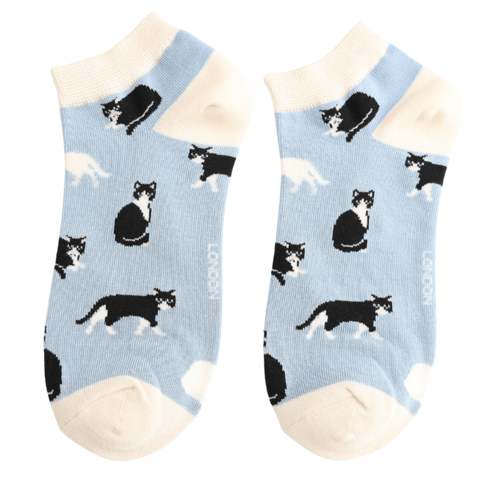 Pair of Miss Sparrow ladies' powder blue bamboo trainer socks featuring playful black and white cats in different poses with cream cuffs, heels and toes.
