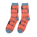 Pair of Miss Sparrow Ladies Bamboo Socks in vibrant orange featuring playful black cat silhouettes sitting on musical staves with navy music notes and contrasting blue-grey heels, toes and cuffs.