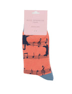Miss Sparrow Ladies Bamboo Socks in vibrant orange with playful black cat silhouettes and musical notes, displayed in branded gift packaging with contrasting blue-grey toe.