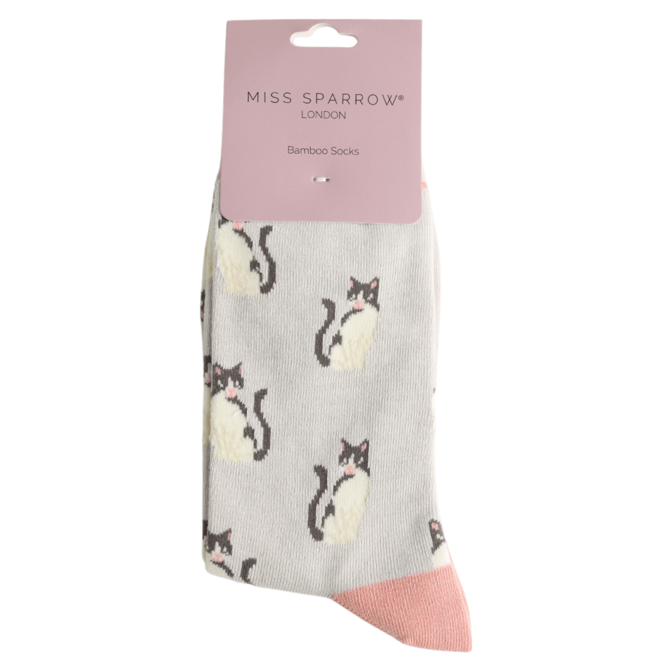 Miss Sparrow ladies' bamboo socks featuring adorable black and white cats on a soft silver grey background with pink heels, toes and cuffs, displayed in branded packaging.