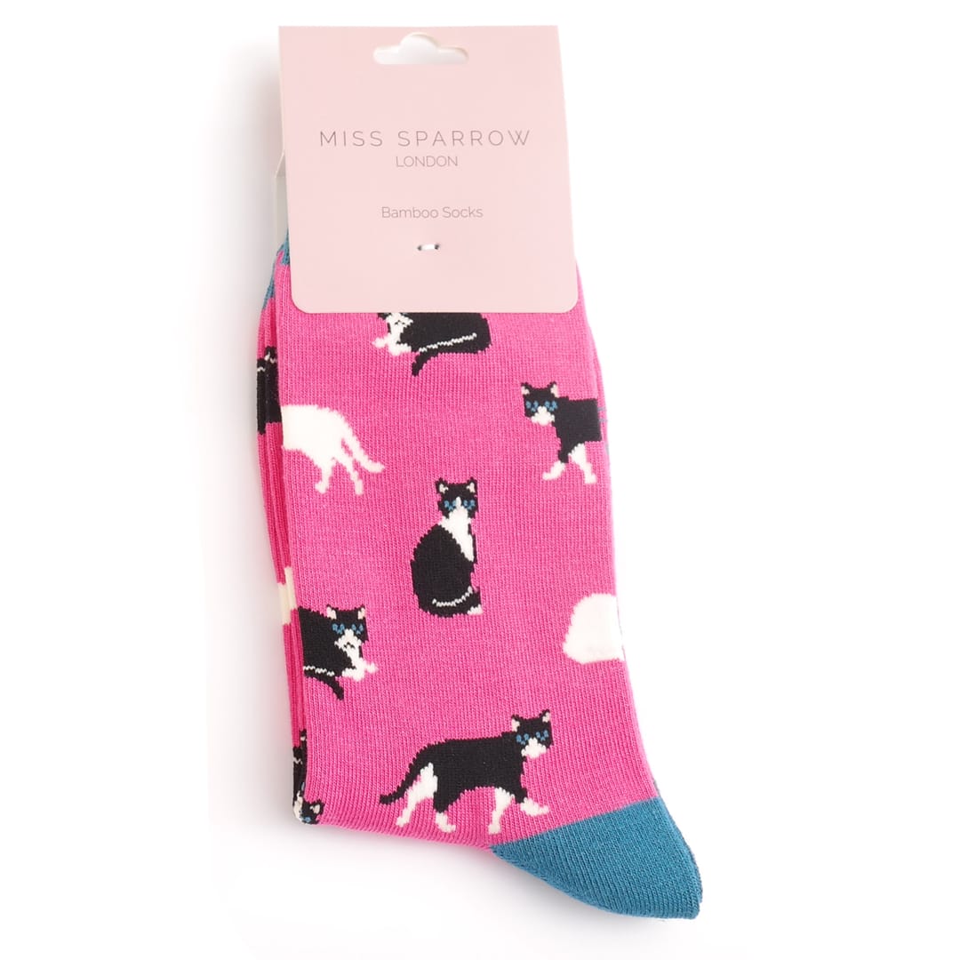 Miss Sparrow Ladies Bamboo Socks in vibrant fuchsia pink featuring playful black and white cat silhouettes with contrasting teal heels, toes and cuffs, displayed in branded gift packaging.