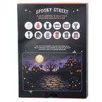 Back of Spooky Street 12-day Halloween advent calendar showing 12 miniature surprises and moonlit haunted village backdrop to cut out