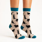 Lady in tiptoes wearing Ladies grey bamboo socks featuring playful black cats with teal heels, toes and cuffs by Socktopus.