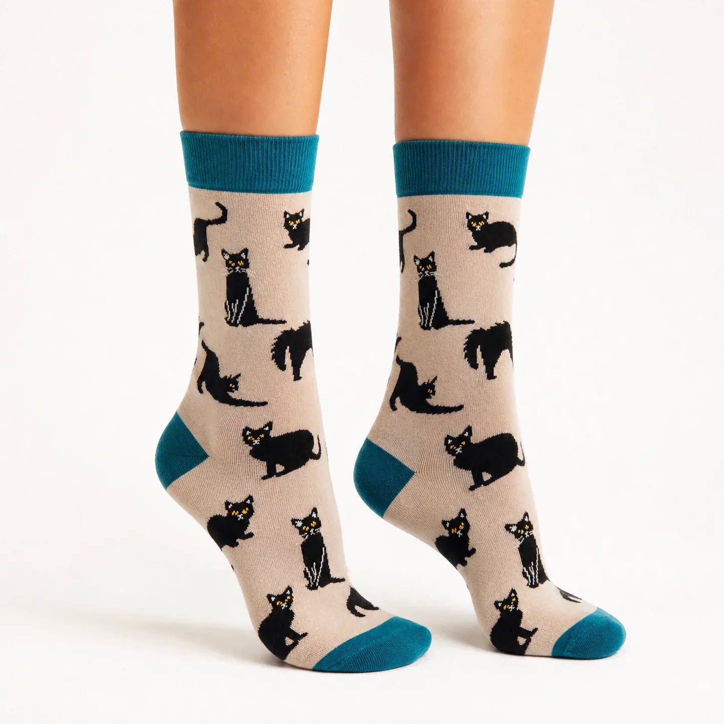 Lady in tiptoes wearing Ladies grey bamboo socks featuring playful black cats with teal heels, toes and cuffs by Socktopus.