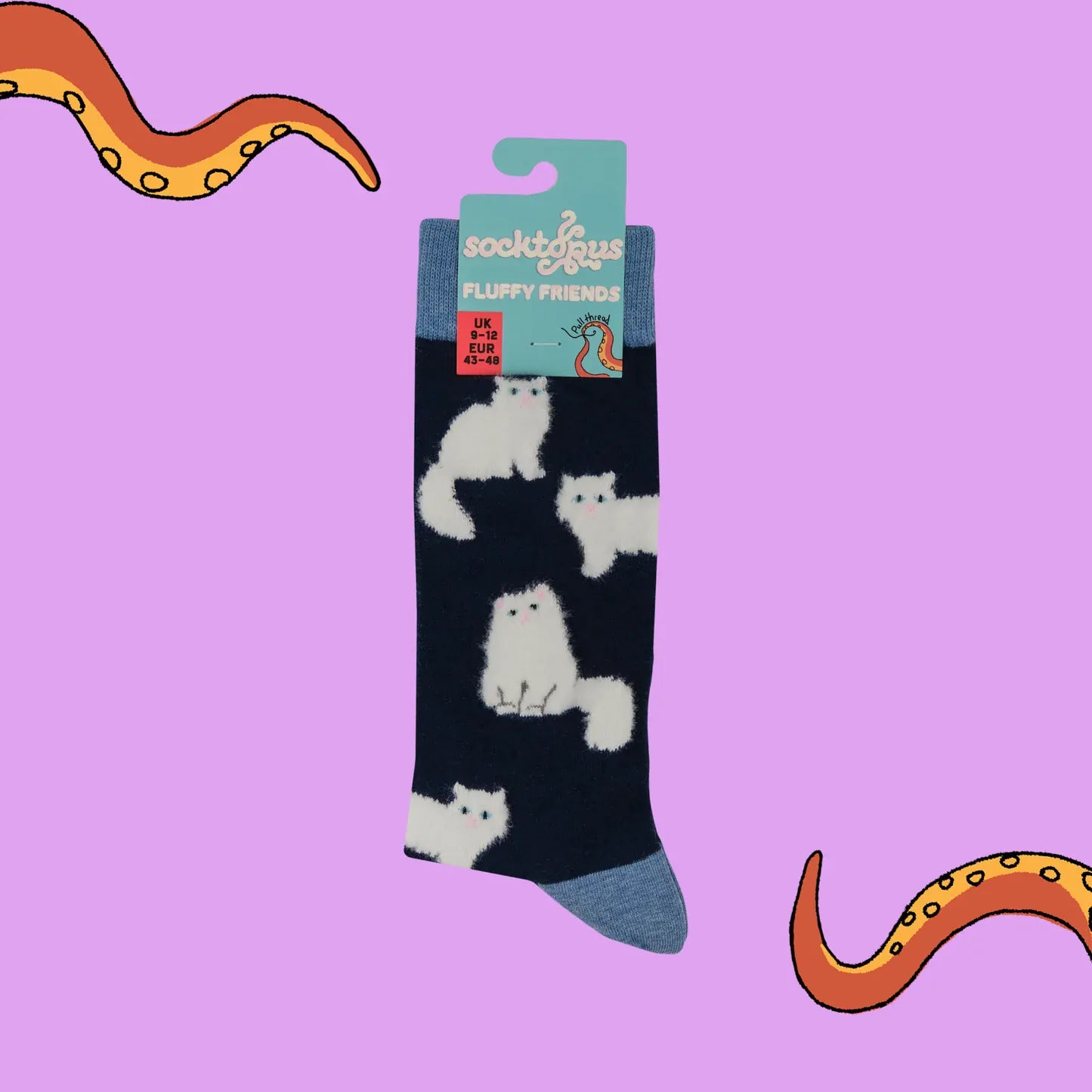 Socktopus Fluffy White Cats combed cotton socks in retail packaging, featuring soft textured white cats on a navy background with pale blue cuffs, heels and toes.