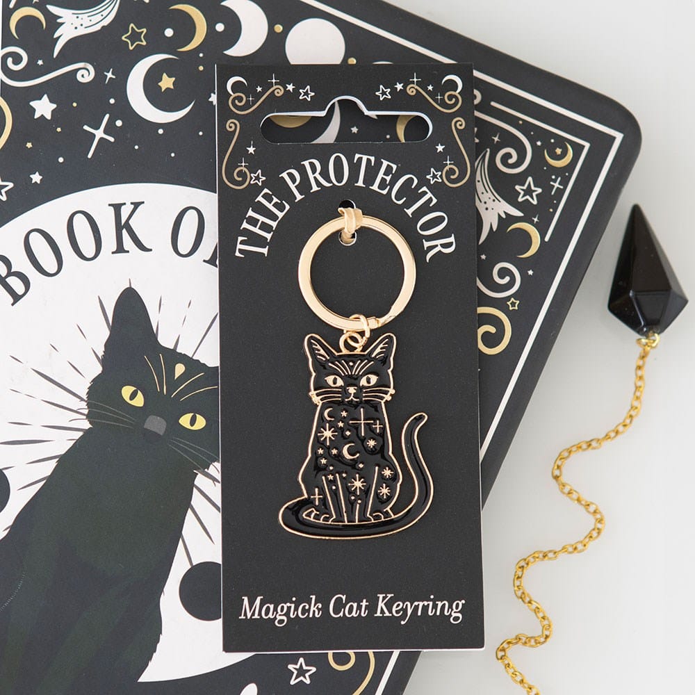 The Protector Magick Black Cat Keyring with celestial moon and star design displayed beside a mystical black cat Book of Spells