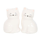 White ceramic cat salt and pepper shakers featuring two adorable smiling cats with pink ears, black whiskers and glossy finish, sitting side by side.
