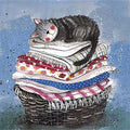 Alex Clark Laundry Basket greeting card featuring a sleepy grey tabby cat curled up on folded colourful blankets in a wicker laundry basket.Basket